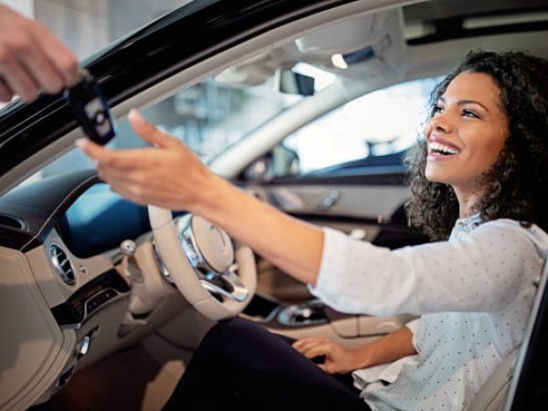Car dealer is giving key for a new car to a woman